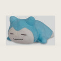 Center: Snorlax Comfy Cuddlers Plush